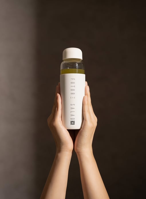 Set of Hands Holding Future Salad Bottle with Future Salad Detox Mix Drink