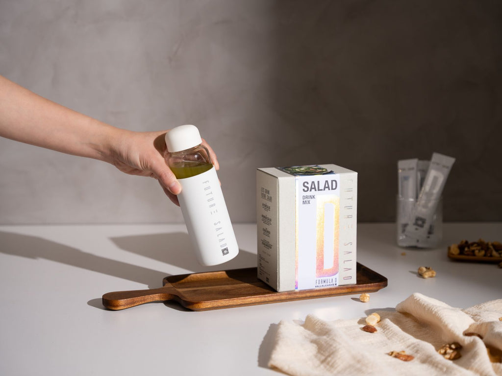 Hand Holding Future Salad Detox Drink Mix in a Bottle